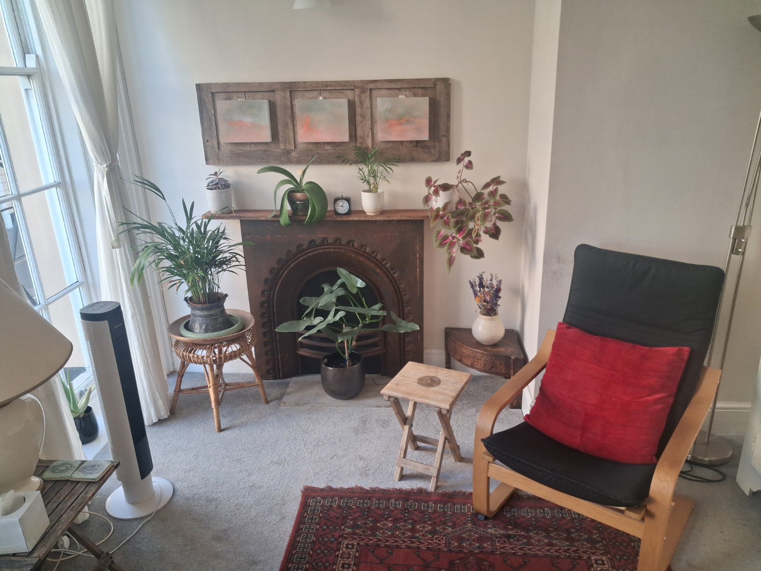 A calm therapy room with plants, fireplace and armchair